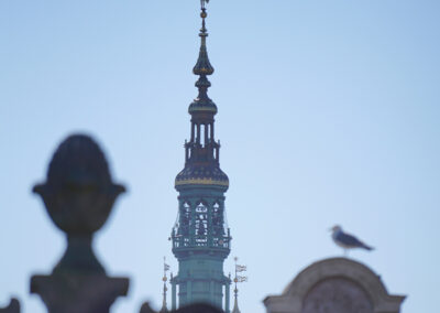 Widok z oddali na wieżę Ratusza Głównego Miasta w Gdańsku z widocznymi dzwonami carillonu.