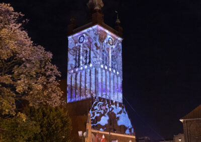Wieża kościoła św. Katarzyny w Gdańsku podczas koncertu z pokazami wyświetlanych na niej pokazów wizualizacji świetlnych